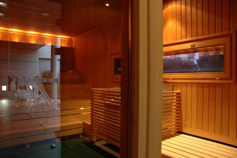 Deckchairs reflected in the door of a wooden sauna