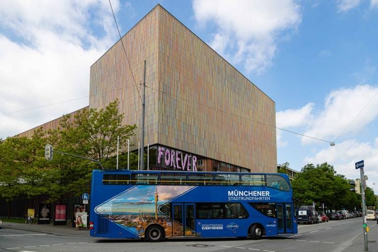 A blue double-decker sightseeing bus in front of Museum Brandhorst