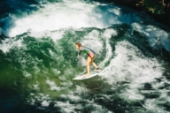 Female surfer catching a wave on the Eisbach in Munich