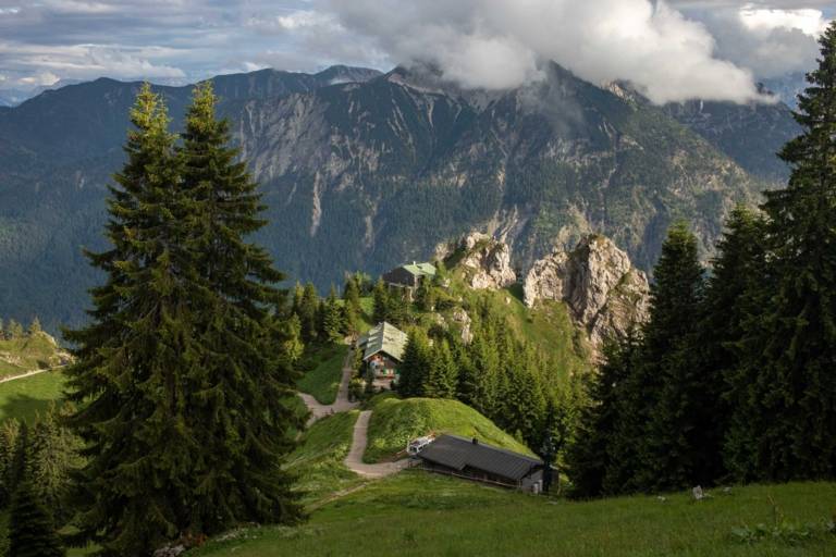 View of an alpine hut in front of a mountain panorama in Munich.