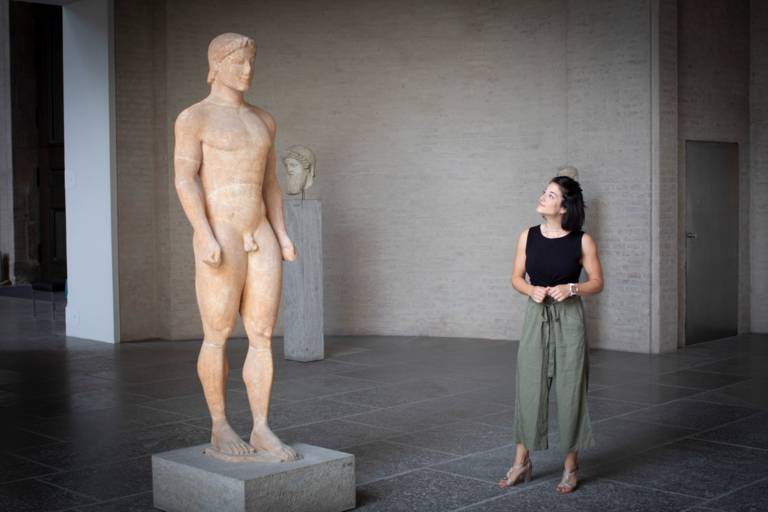 Personal Trainer Alexandra Horn stands in front of a sculpture in the Glyptothek in Munich.