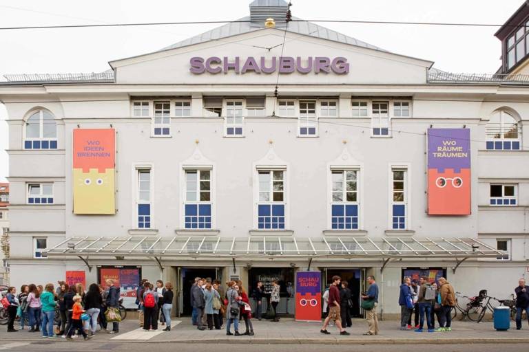 The façade of the Schauburg Children's and Youth Theatre with visitors in front of the entrance.