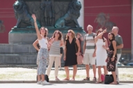A guide shows a group of tourists the city