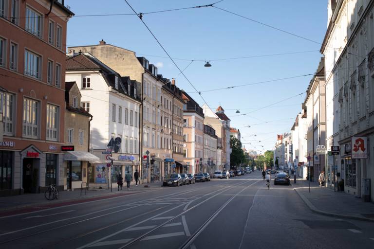 There are several old buildings on a street with tram tracks