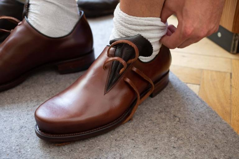 A man tries on a brown traditional leather shoe