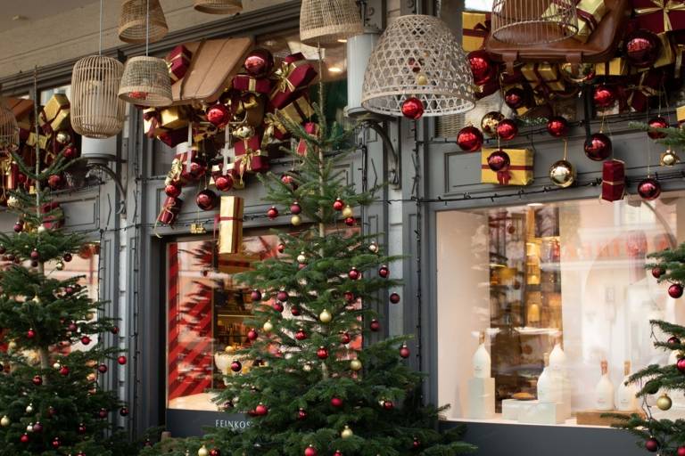 Decorated Christmas trees and gifts decorate shop windows