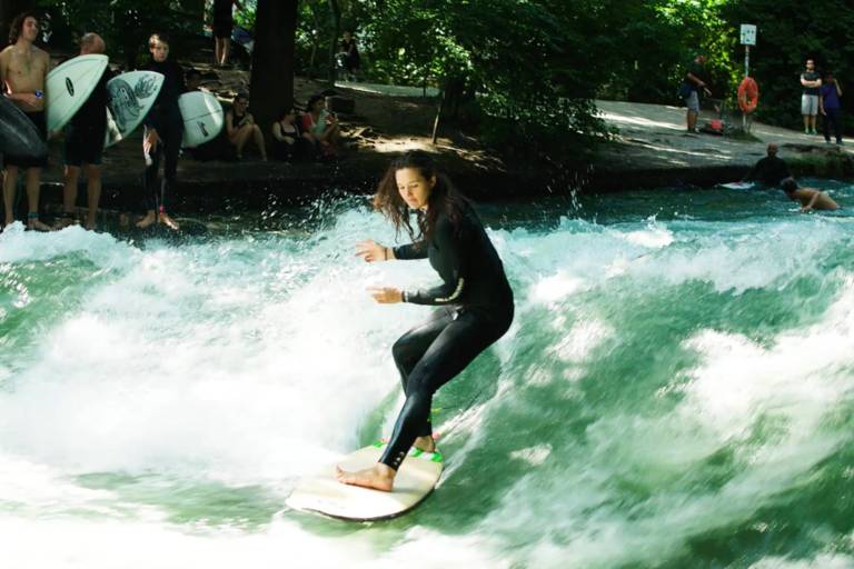 A female surfer surfing on the Eisbach in Munich